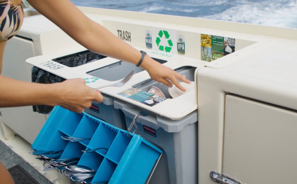 Woman throwing away trash on board the Fair Wind