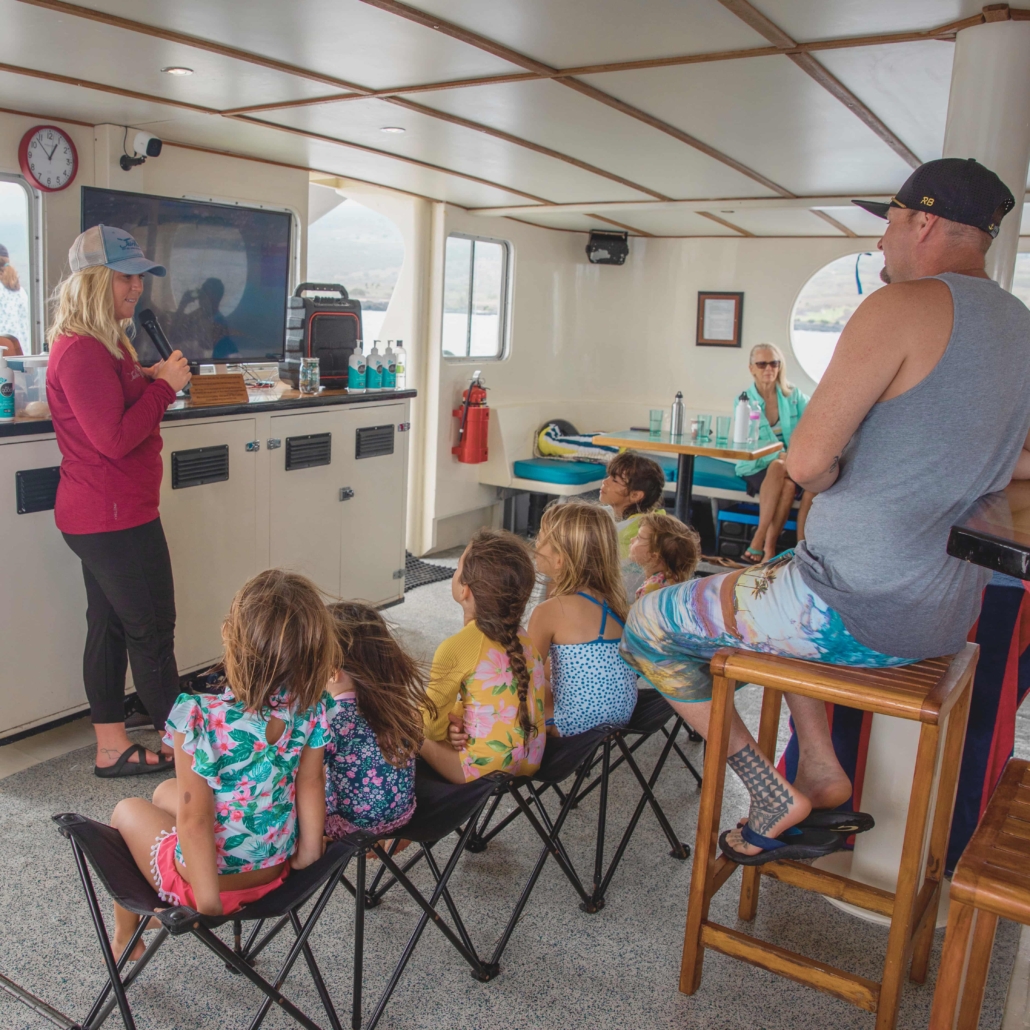 A crew member aboard the Fair Wind teaching children about marine wildlife